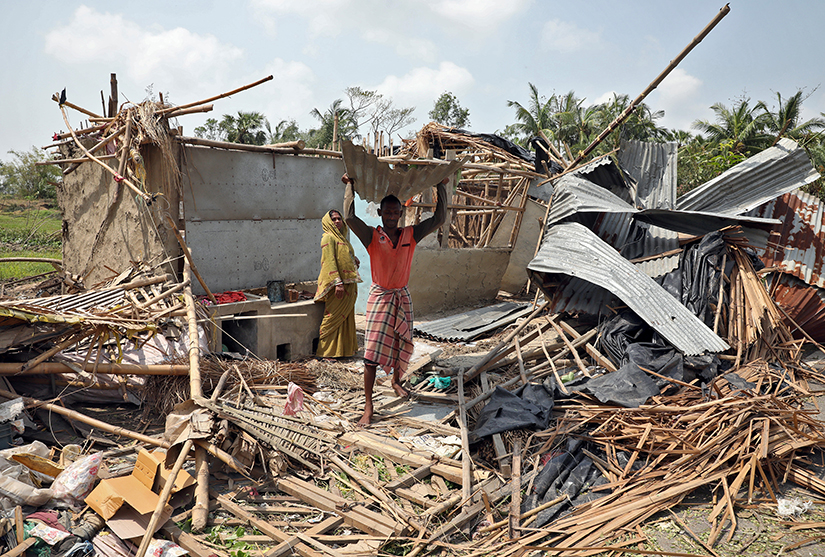 A man carried a tin sheet salvaged from the rubble of his damaged house in a village near Kolkata, India, May 22, in the aftermath of Cyclone Amphan.