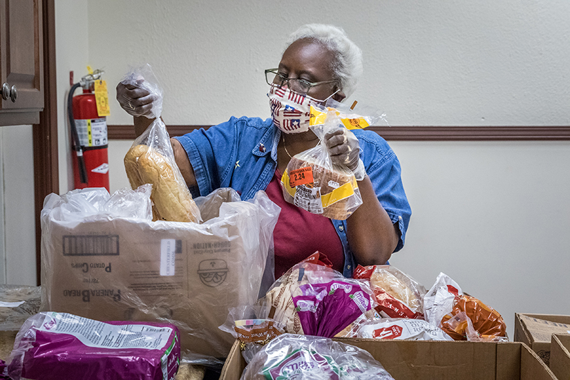 Ella Scott unpacked bread to give away at the St. Nicholas Parish St. Vincent de Paul food pantry at the former Visitation/St. Ann Shrine Church in St. Louis on June 23. “What God calls us to do is serve,” said Scott, a volunteer at the food pantry.