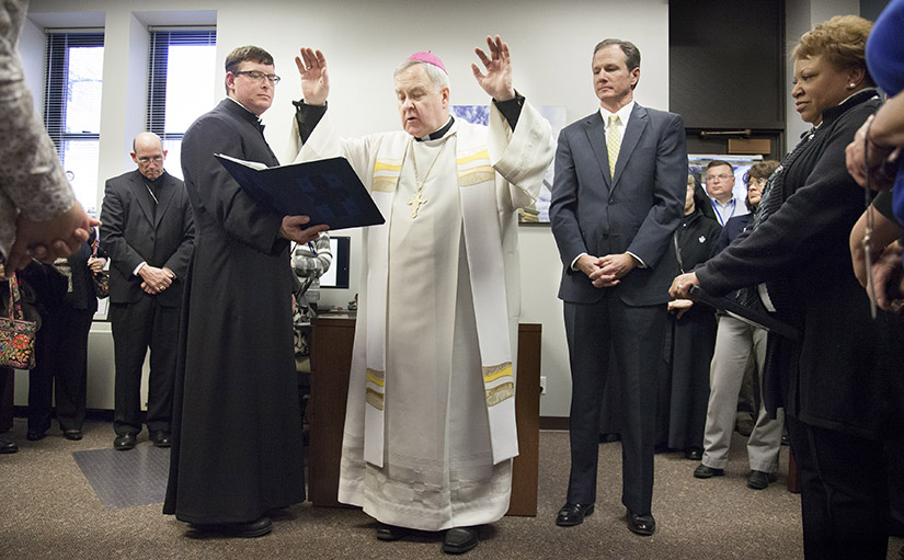 Archbishop Robert J. Carlson blessed the new offices of the Roman Catholic Foundation of Eastern Missouri in 2013. The foundation was launched to provide individuals with the opportunity to invest in various initiatives supported by the Church. The president of the foundation, Mark Guyol, stood next to the archbishop.