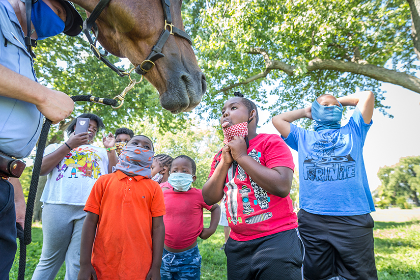 Jamarion Scott talked to Tank, a Quarter Horse with the St. Louis Metropolitan Police Department’s Mounted Patrol, at Camp Sun Splash at Fairground Park in St. Louis on Aug. 21.