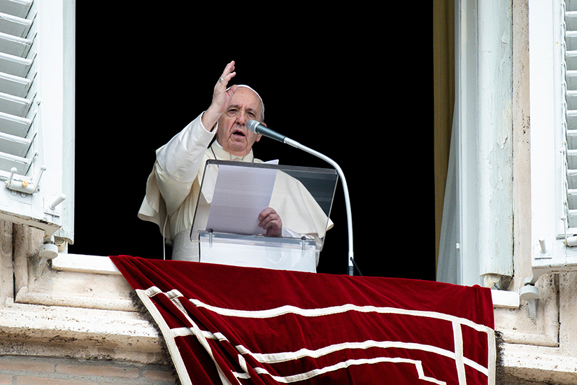 Pope Francis delivered a blessing as he led the Angelus from the window of his studio overlooking St. Peter’s Square at the Vatican Aug. 30.