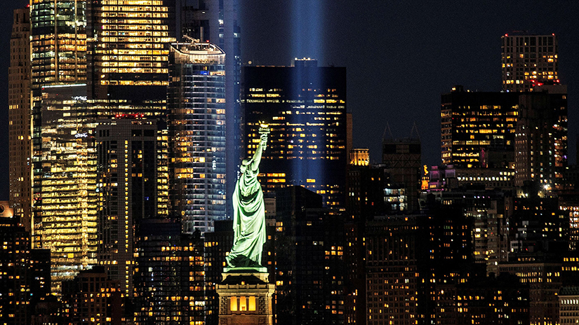 The Statue of Liberty is seen in New York City as the Tribute in Light installation shines behind it to mark the 19th anniversary of the 9/11 terrorist attacks on the World Trade Center.