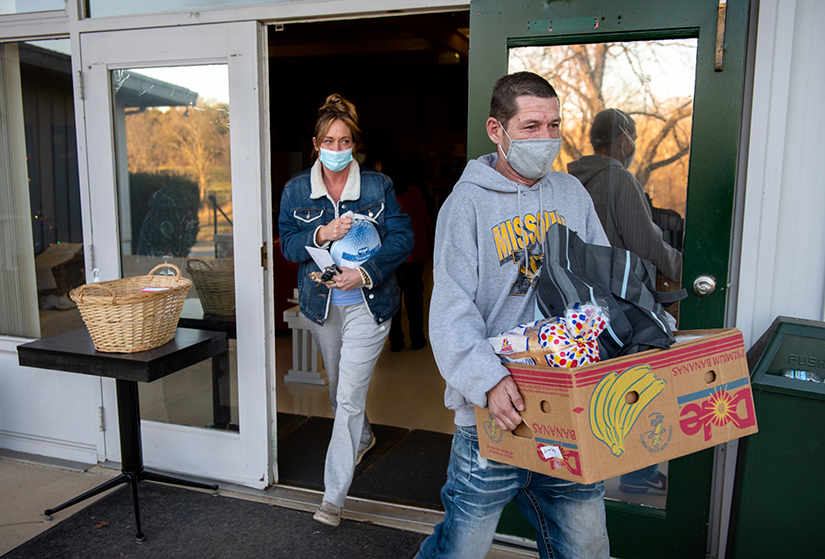 Volunteer Ronald Niswanger, right, helped load Megan Pierce’s car with Christmas gift boxes for families in need of assistance from the Rural Parish Workers of Christ the King Dec. 21. The group canceled its 2020 fundraising event and instead asked people to contribute what they could, raising $112,000.