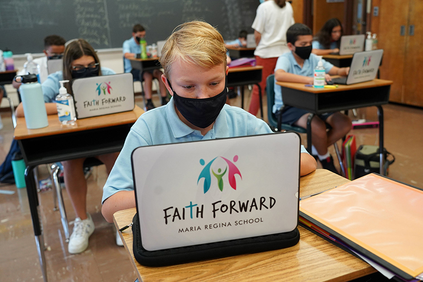 Seventh-grader Drew Houck used a laptop during class Sept. 17 at Maria Regina School in Seaford, N.Y. Whether operating with remote or in-person learning, Catholic schools are requiring increased assistance from their IT teams, which sometimes are volunteers.