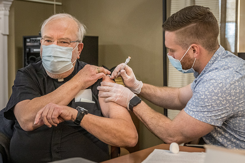 Walgreen’s pharmacist Josh Guinn vaccinated Father Robert Reiker, pastor of St. Bernadette Parish in Lemay, with a COVID-19 vaccination. More than 90 older or retired priests and staff of Regina Cleri in Shrewsbury were vaccinated with the Moderna vaccine Jan. 29. 