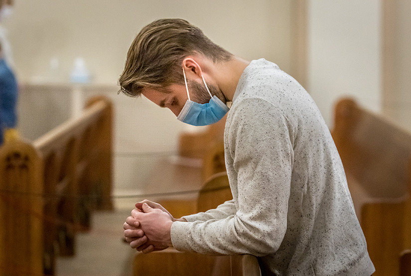 Maxime Kaiser, a student at Lindenwood University from France, prayed during Mass at St. Peter Parish in St. Charles on Feb. 21.  