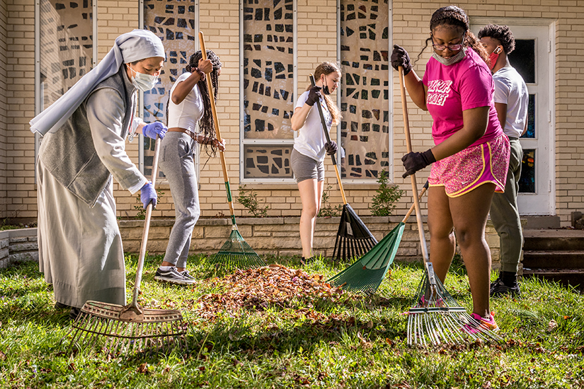 Sister Mary Dang, a Missionary Sister of St. Peter Claver, and Bishop DuBourg High School students Praise Lanelee, Jenna Kennison, Taniyah Morrow and Jaidon Gardner raked leaves at the sisters’ convent in Chesterfield April 9. “These kids are amazing!” exclaimed Sister Mary of the students, who were doing a service project at the convent.