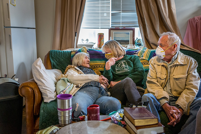 Kim Reifschneider, left, who just celebrated one year of living in her tiny house behind Sts. Teresa and Bridget Church in St. Louis, visited with Bob and Dianne Marshak in her home April 15.