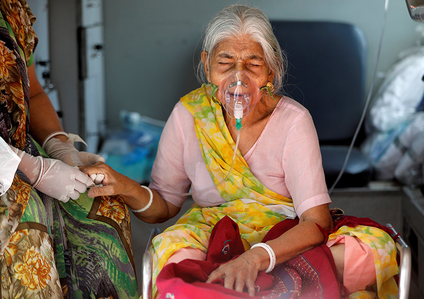 Lilaben Gautambhai Modi, 80, wearing an oxygen mask, waited inside an ambulance before entering a COVID-19 hospital for treatment in Ahmedabad, India, May 5.