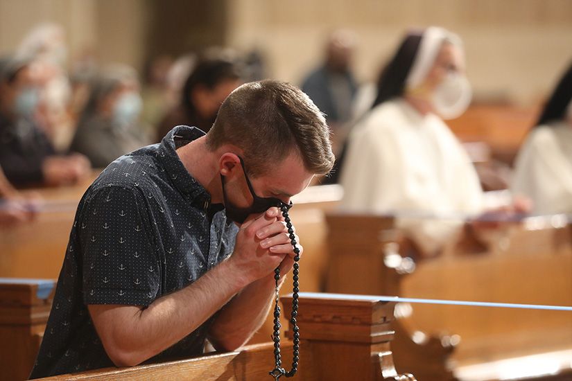 A man prayed the Rosary at the Basilica of the National Shrine of the Immaculate Conception in Washington May 17. The Rosary, led by Washington Cardinal Wilton D. Gregory, was part of a worldwide effort called by Pope Francis to pray for an end to the coronavirus pandemic.