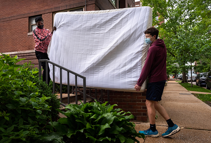 Evan Hugge, right, a student at Saint Louis Priory School, helped Djuma Dunia, a Congolese immigrant, carry a mattress on May 28 in the DeBaliviere Place neighborhood in St. Louis. The mattress and other bedroom furniture was donated to St. Louis Teens Aid Refugees Today to give to Dunia’s family.
