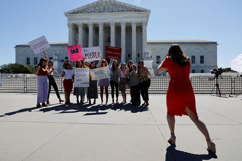 Women posed for a picture near the U.S Supreme Court building in Washington June 17. In a unanimous decision June 17, the Supreme Court said that a Catholic social service agency should not have been excluded from Philadelphia’s foster care program because it did not accept same-sex couples as foster parents.