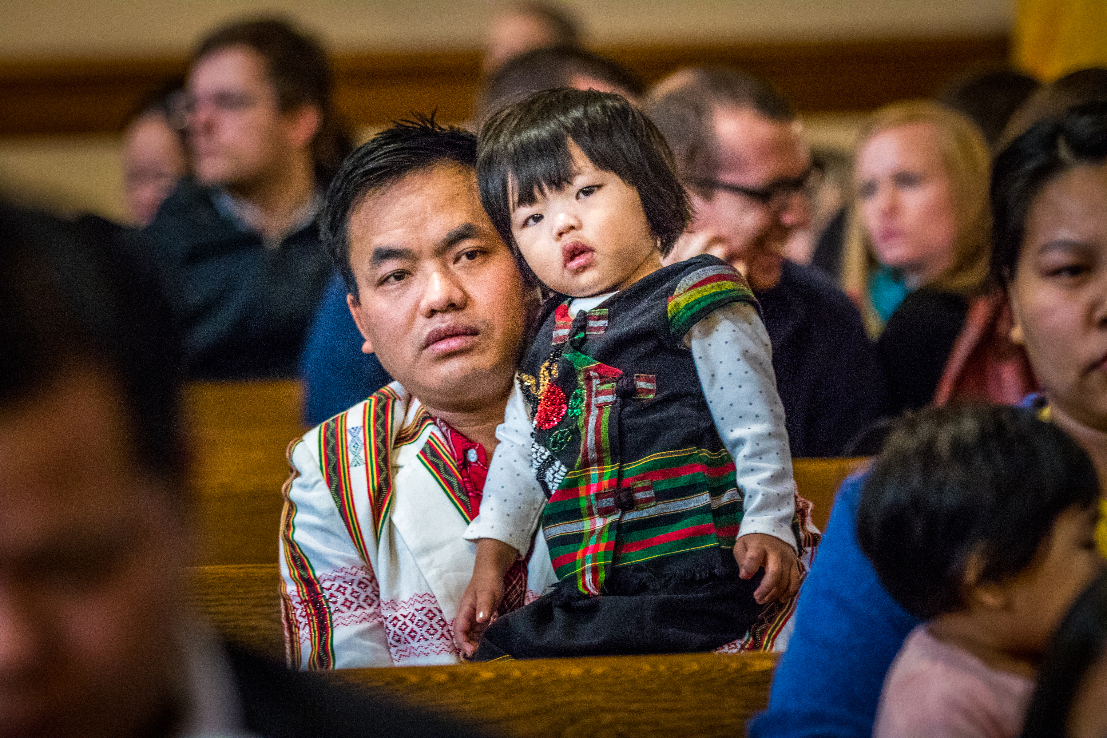 Before the annual Migration Mass at St. Pius V Church in St. Louis in 2017, Lian Khartoum Pinang settled his 2-year-old daughter, Don Ngaih Lun. The parish has a large immigrant community.