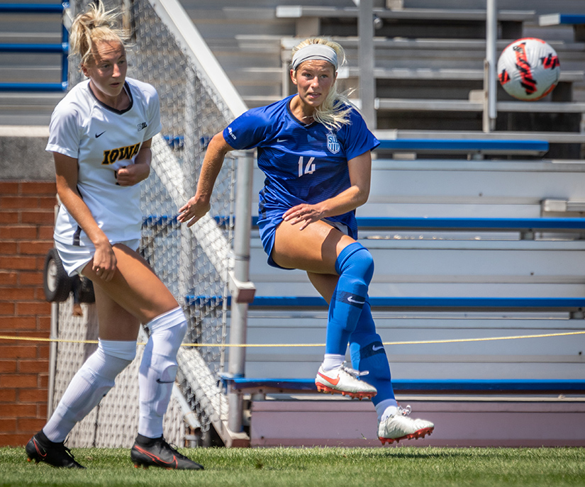 Saint Louis University’s Karsen Kohl passed the ball past the University of Iowa’s Samantha Cary during the game at SLU on Aug. 16. SLU lost to Iowa 1-0.