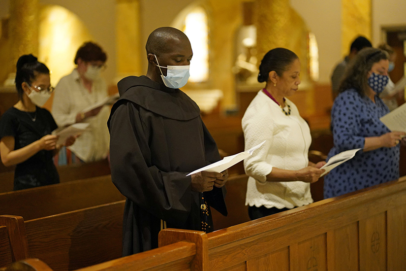 Franciscan Father Abraham Joseph and other participants prayed during a prayer service for Haiti and Afghanistan Aug. 23 at St. Francis of Assisi Church in New York City. Father Joseph was born in Les Cayes, Haiti, epicenter of the earthquake.