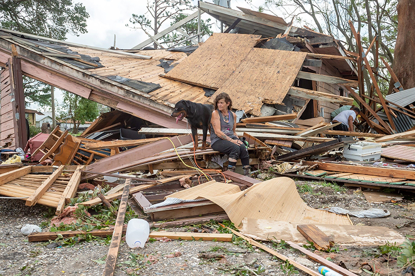 Fran Tribe sat with her dog, Dave, outside a home in Houma, Louisiana, Aug. 30, after Hurricane Ida made landfall.