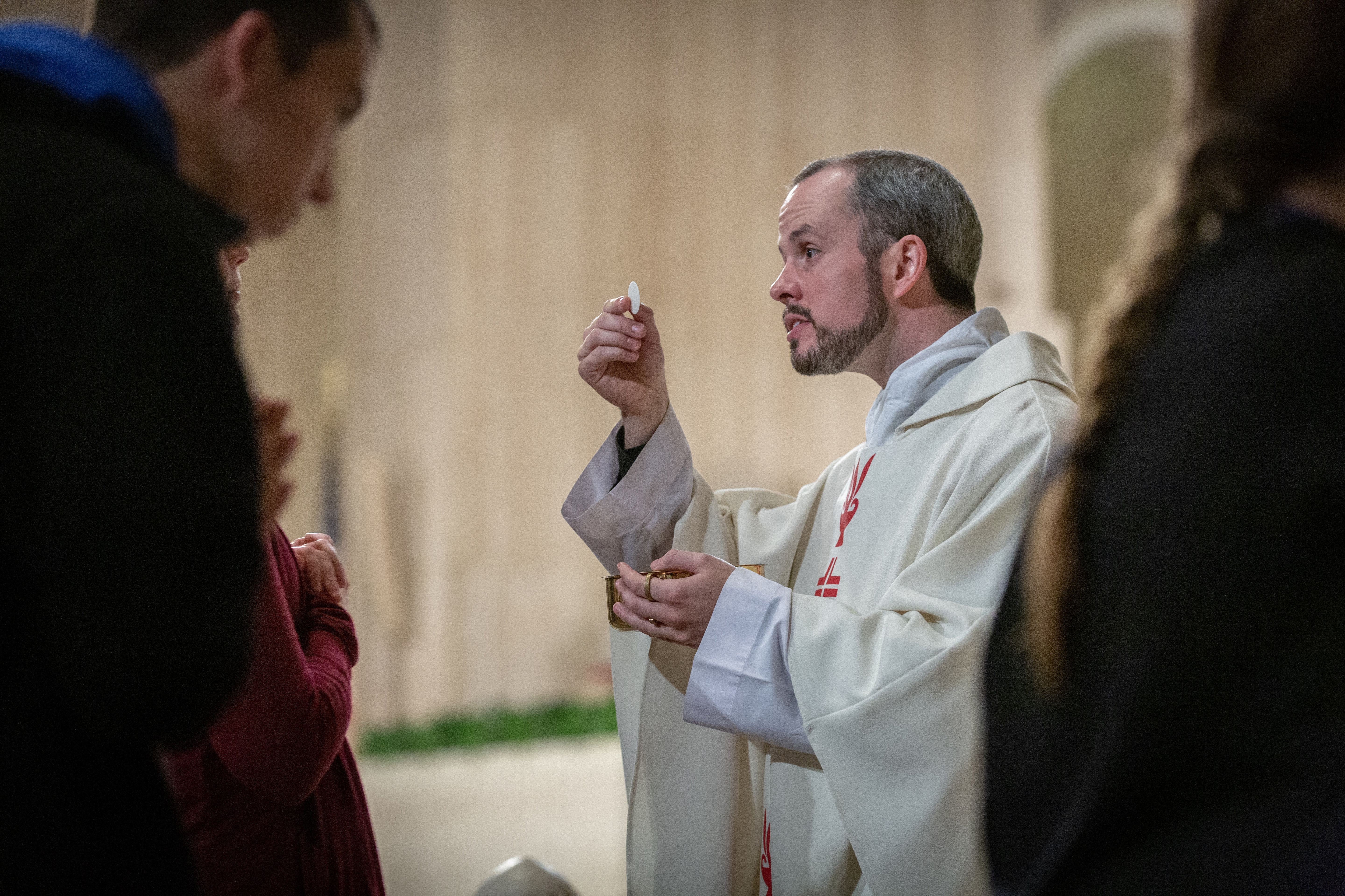 Father Conor Sullivan distributed the Eucharist during Mass celebrated by Archbishop Robert J. Carlson for youth attending the Generation Life pilgrimage on Jan. 19, 2019.
