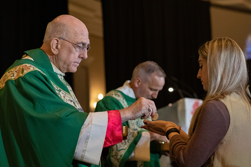 Archbishop Joseph F. Naumann distributed Communion at Mass for the Respect Life Convention Oct. 17.