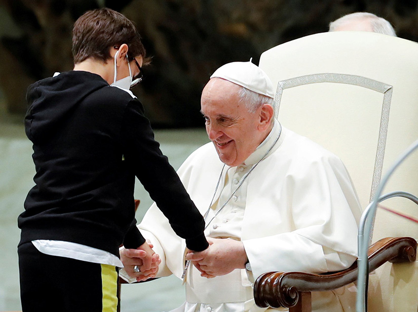 Pope Francis greeted 10-year-old Paolo after the boy spontaneously walked on to the stage during the weekly general audience at the Vatican Oct. 20.
