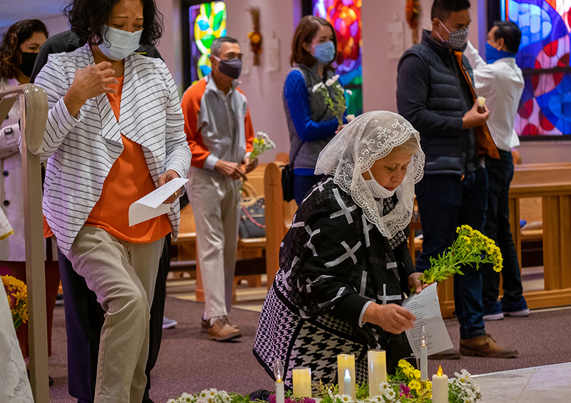 Members of the Filipino Catholic community who lost a loved one during the past year placed candles and flowers on the altar at a Todos Los Santos Mass at St. Jude Church in Overland Nov. 7.