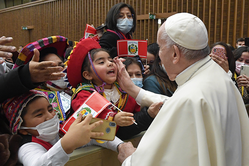 Pope Francis greeted a child during an audience in the Paul VI Hall at the Vatican Dec. 10 with delegations from Italy and Peru who donated the Christmas tree and Nativity scene displayed in St. Peter’s Square.