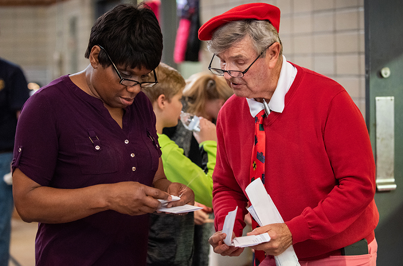 Msgr. Robert Gettinger, right, handled some paperwork during a work day packing Christmas baskets with non-perishable items for distribution to those in need by the ministry Father Bob’s Outreach in 2018. Father Bob’s Outreach assists people in need in St. Louis, primarily in the areas served by St. Augustine and St. Elizabeth, Mother of John the Baptist parishes.