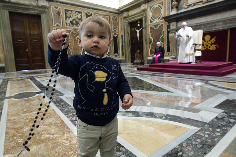 Pope Francis spoke as a boy held a rosary during a meeting with children from Italy’s Catholic Action at the Vatican Dec. 18.