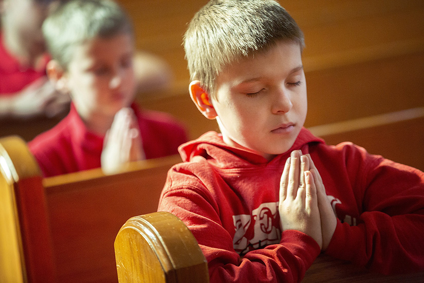 Peyton Ladd, front, and Emmett Abts, both third-graders at St. Joseph School in Zell, prayed during a guided meditation Jan. 20 at the church. Father Henry Purcell, pastor of St. Joseph, and teachers at the school are teaching students how to engage in a conversational style of prayer.