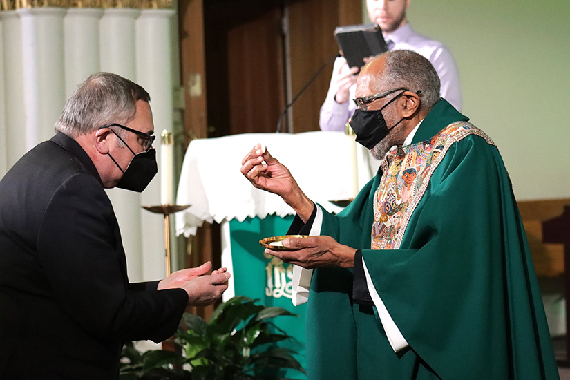 Msgr. Ray East, pastor of St. Teresa of Avila Catholic Church in Washington, distributed Communion during the Catholic Social Ministry Gathering’s opening Mass Jan. 29. It was livestreamed for the 800-plus participants of the annual gathering, held virtually for the second year in a row because of the pandemic.
