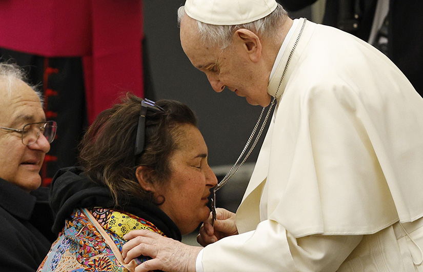 A woman kissed Pope Francis’ cross as he left his general audience in the Paul VI hall at the Vatican Feb. 23.