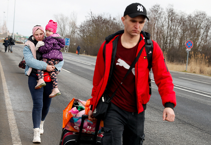 A family fleeing from Ukraine carried their belongings at the Hungarian-Ukrainian border in Beregsurány, Hungary, Feb. 24 after Russian President Vladimir Putin authorized a military operation in Ukraine.