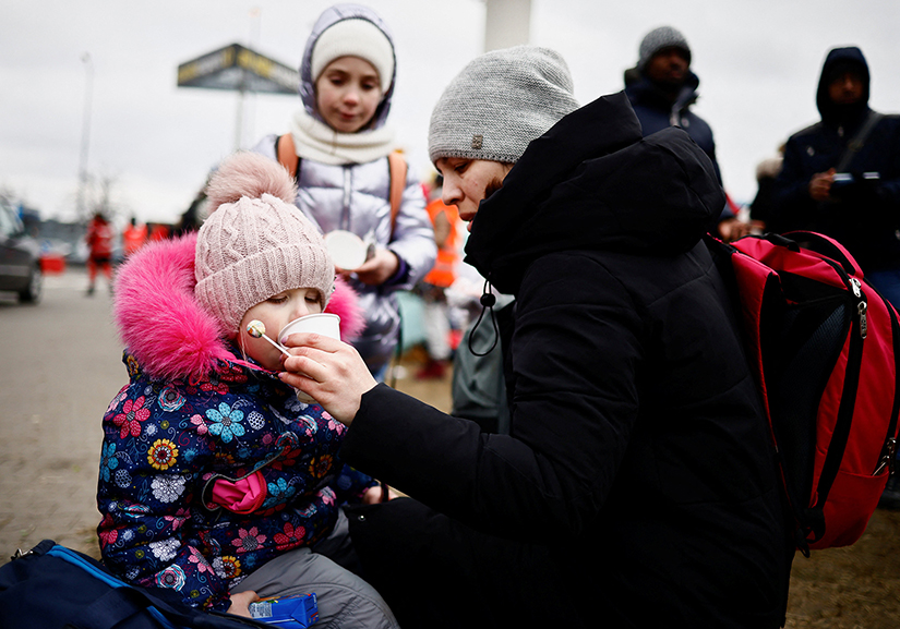 A mother gave water to her daughter at a temporary camp in Przemysl, Poland, Feb. 28 as they fled the Russian invasion of Ukraine. Many volunteers in Poland and other European countries are assisting Ukrainians who are fleeing the fighting.