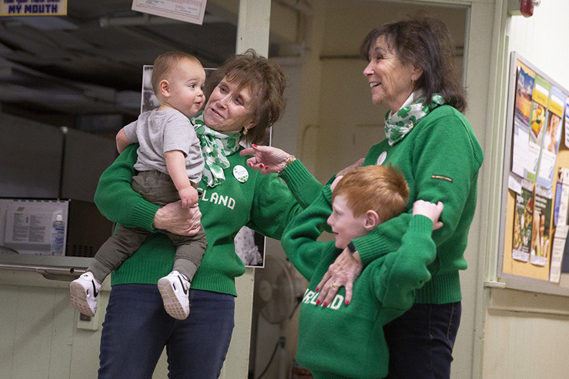 Mary Anne Miller of St. Joseph Parish in Cottleville, left, held her 15-month-old grandson Beckett Miller, as she shared a moment during the singing of Happy Birthday with her twin sister Theresa Kirchmer of Ste. Genevieve Parish in Ste. Genevieve and her 4-year-old grandson Graham Collier. The twins celebrated their 71st birthday with Mass at Our Lady of the Holy Cross Church, the final stop on a journey to visit 70 churches for their 70th birthday, a journey extended a year by the COVID-19 pandemic.
