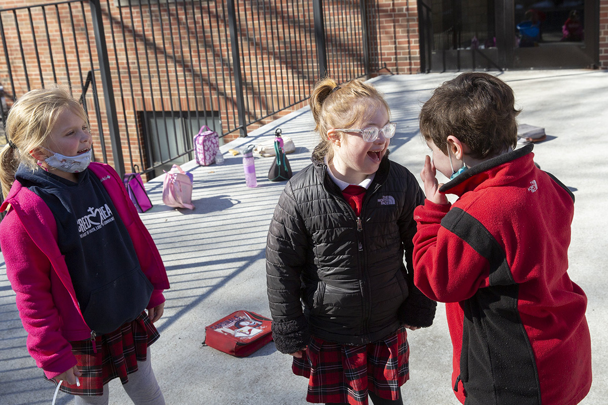 Sacred Heart School first-grader Rose Daub, center, laughed with classmate Kane Spann, right, and Addison O’Donnell at recess in February at Sacred Heart School in Florissant.
