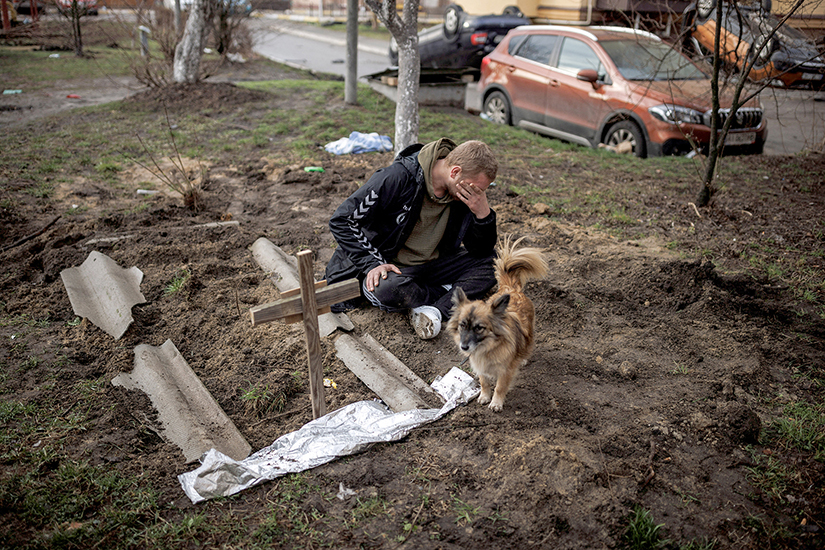 A man mourned next to the grave of his friend in Bucha, Ukraine, April 6. The Ukrainian Council of Churches and Religious Organizations as well as individual religious leaders have condemned the atrocities apparently committed by Russian troops in Bucha and other cities. 