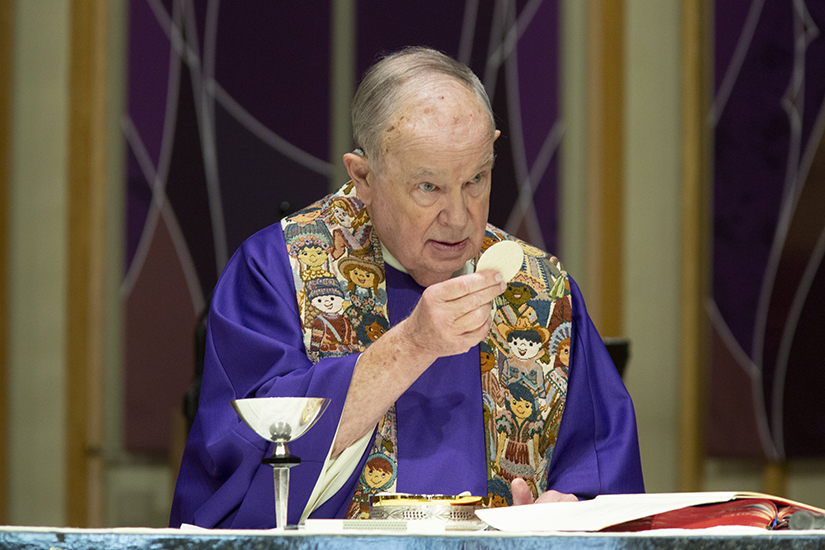 Father John Johnson prayed during the liturgy of the Eucharist April 1 at St. Justin Martyr Church in Sunset Hills. Father Johnson, who is now retired, continues to serve in priestly ministry at the parish.