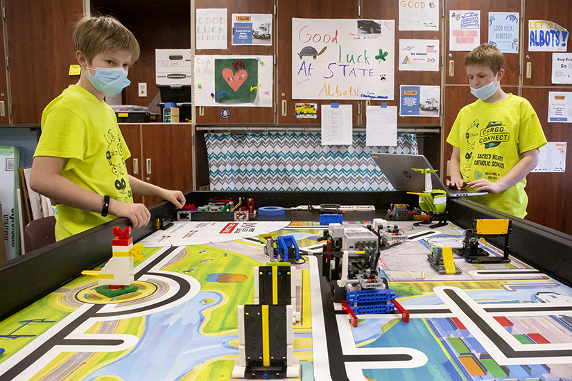 Brothers Ryan Mitchell, left, and Alex Mitchell, sixth- and eighth-graders respectively at Sacred Heart School in Valley Park, practiced with a robot on a gameboard during a meeting of the Albots robotics team April 7 at Sacred Heart School in Valley Park. The Albots will be competing in the FIRST Championship in Houston April 20-23.