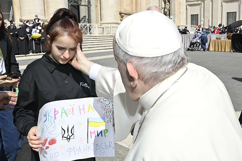 Pope Francis greeted a girl while meeting with a group of Ukrainians after his weekly general audience in St. Peter’s Square at the Vatican April 27.