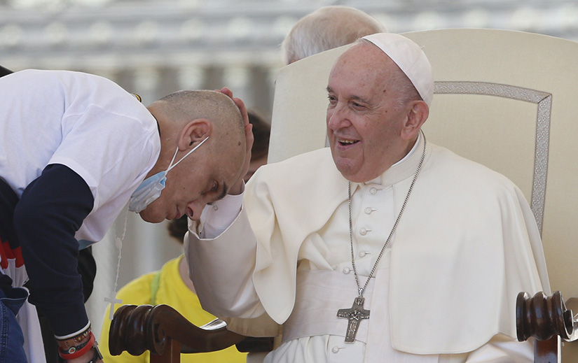 Pope Francis blessed a man as he greeted people during his general audience in St. Peter’s Square at the Vatican May 18.