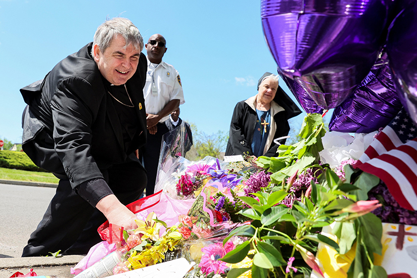 Bishop Michael W. Fisher of Buffalo, N.Y., placed flowers at a memorial May 17 in the wake of a weekend mass shooting at a Tops supermarket.