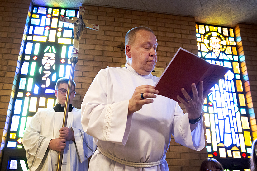 Acolyte Jim Bohnert, center, led the Stations of the Cross on Good Friday, April 15, at St. Paul Church in Fenton. Bohnert will be ordained as a permanent deacon June 4.