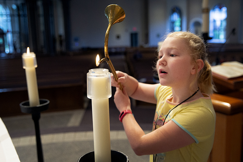 Maria Cook practiced lighting candles for Mass during a server camp May 26 at Assumption of the Blessed Virgin Mary Parish in O’Fallon.