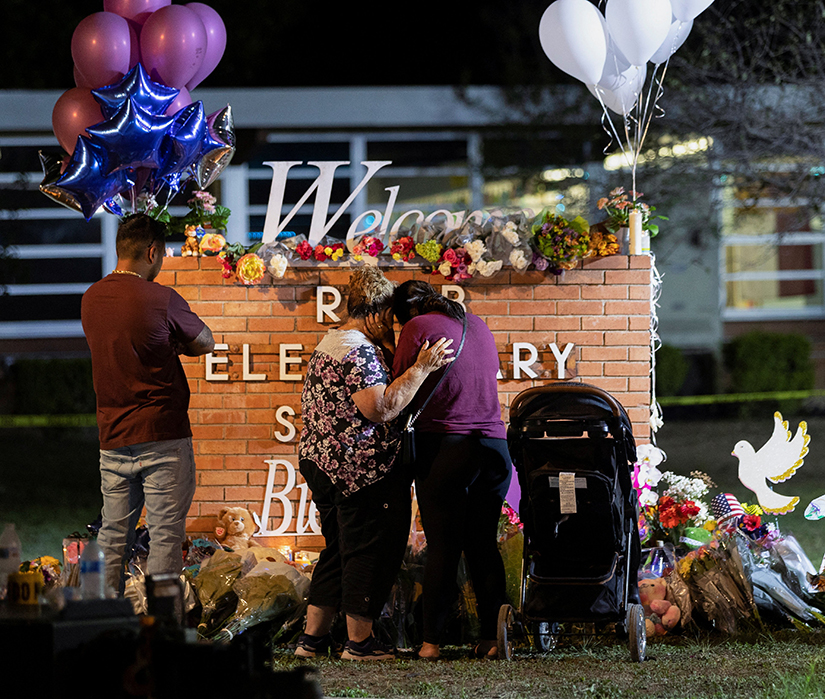 People mourned at a memorial May 25 outside Robb Elementary School, the site of a mass shooting in Uvalde, Texas.