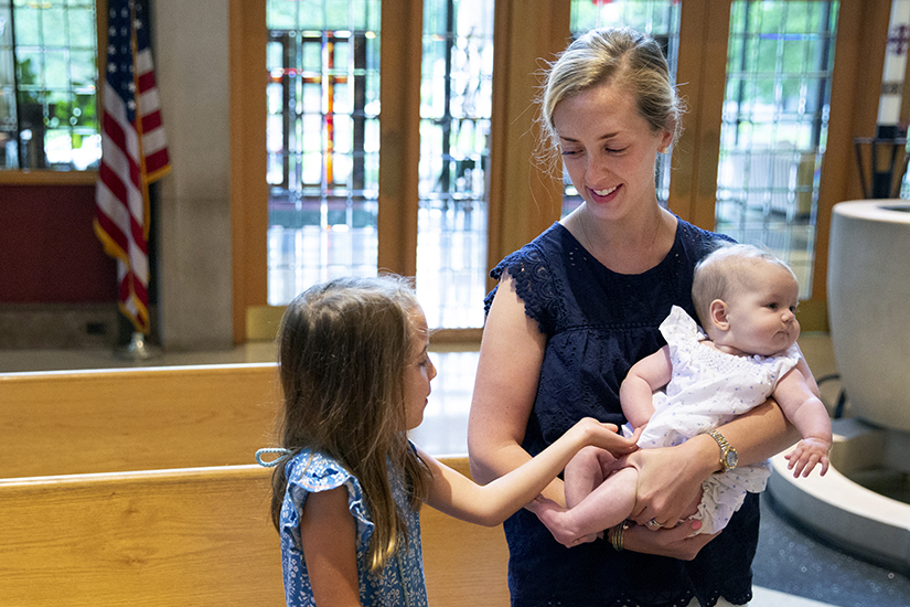 Caroline Rosa, a parishioner at St. Peter Church in Kirkwood, smiled at her daughter Maria, 6, while holding her 5-month-old daughter Frances Rosa June 10 at St. Peter Church. The Rosas have been parishioners at St. Peter since 2019.