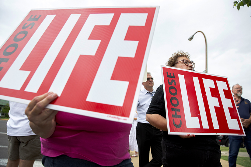 Maria Thompson, right, a parishioner at Assumption Parish in south St. L ouis County, held a "Choose Life" sign during a gathering June 24 outside Planned Parenthood in St. Louis. Earlier in the day, the U.S. Supreme Court released its decision in Dobbs v. Jackson Women's Health Organization, which overturned the court's 1973 Roe v. Wade decision.