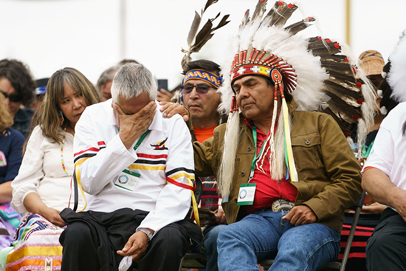 A man is comforted by an Indigenous leader during ceremonies July 25 in Maskwacis, Alberta, where Pope Francis apologized to Canada’s native people on their land for the Church’s role in schools where Indigenous children were abused.