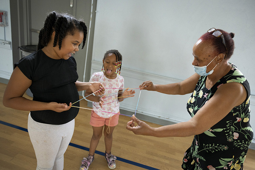 Serenity Williams, left, played with string with Londyn Little-McLemore, center, and Phyllis Hope, a tutor at the Gene Slay’s Girls & Boys Club of St. Louis, on Aug. 4 at the club’s Dutchtown campus in St. Louis.