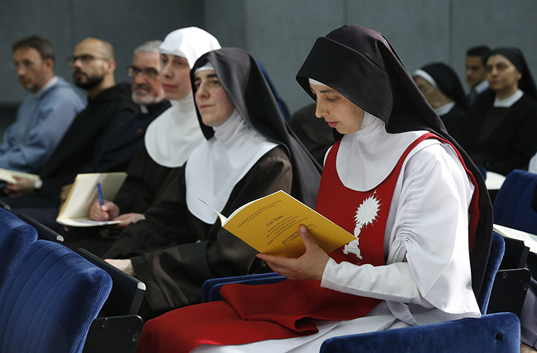A nun held a copy of "Cor Orans," a new instruction for contemplative women religious, during a news conference for its release at the Vatican May 15. The instruction concerns the life, autonomy, supervision and formation of contemplative women religious.