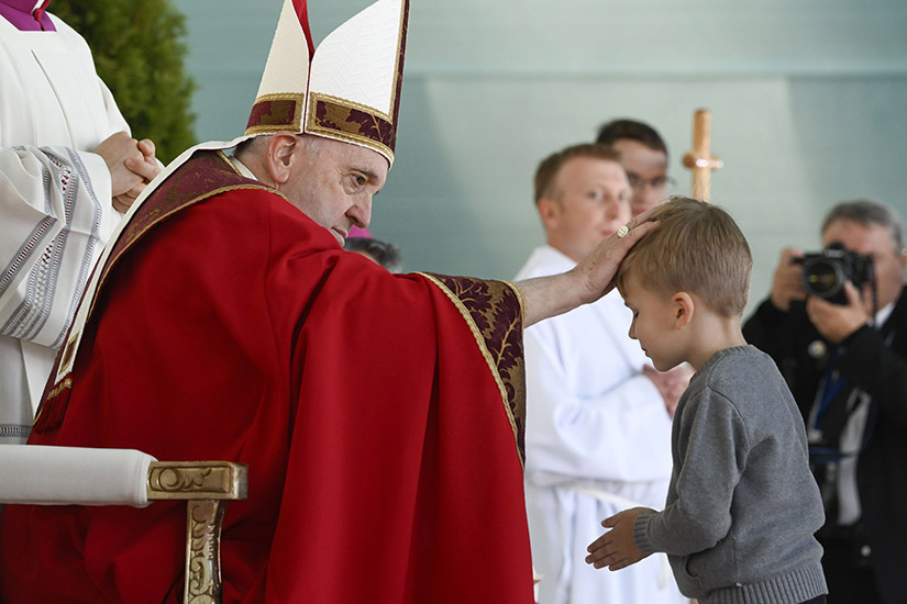 Pope Francis blessed a boy at Mass at the Expo grounds in Nur-Sultan, Kazakhstan, Sept. 14. Reflecting in his homily on the meaning of the feast of the Exaltation of the Cross, Pope Francis said that while the cross “is a gibbet of death,” the Church celebrates it as the means used by Jesus to vanquish evil through love.
