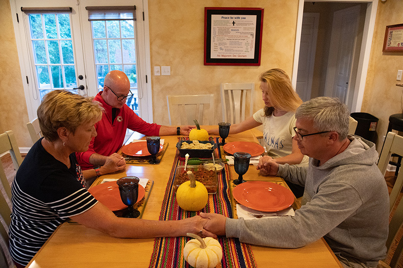 Tom and Mary Hastings prayed with Ukrainian migrants Yulia Alekseyeva and Andriy Kravets ahead of dinner at the Hastings’ home in Chesterfield on Sept. 20. Alekseyeva and Kravets came to the United States as bombs began falling near their home in Lviv in western Ukraine.